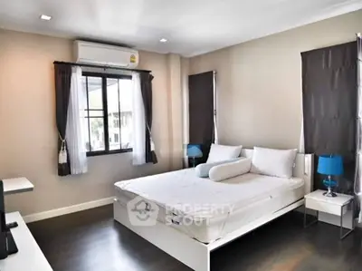 Spacious bedroom with modern decor and large windows for natural light.
