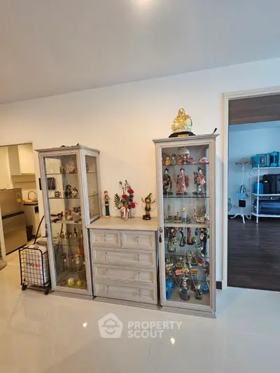 Spacious living area with elegant display cabinets and modern decor