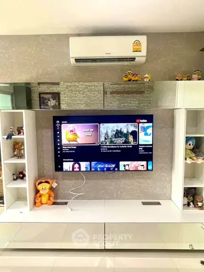 Modern living room with wall-mounted TV and air conditioning, featuring stylish shelving and decor.