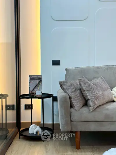 Modern living room with stylish sofa and side table, featuring elegant decor and warm lighting.