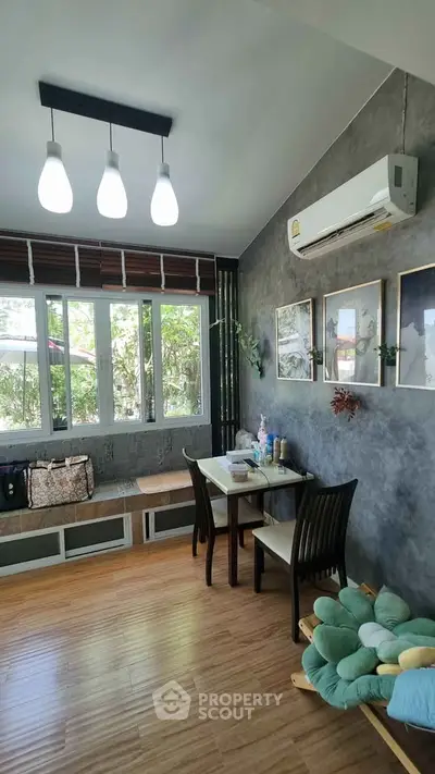 Charming living room with modern decor, large windows, and cozy seating area, perfect for relaxation and entertaining.