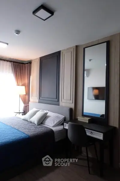 Modern bedroom with stylish decor and natural light, featuring a cozy bed and elegant furnishings.