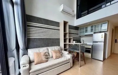 Modern loft-style living room with high ceilings and sleek kitchen area.