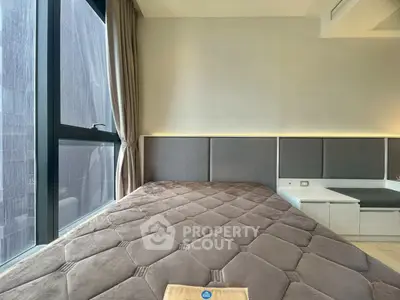 Modern bedroom with large window and stylish decor, featuring a cozy bed and elegant lighting.