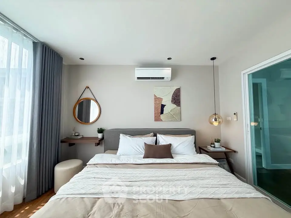 Modern bedroom with stylish decor and natural light, featuring a cozy bed and elegant furnishings.