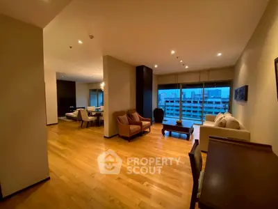 Spacious modern living room with wooden flooring and city view, perfect for urban living.