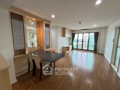 Spacious open-plan living room with city view and elegant wooden flooring.