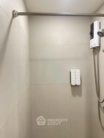 Modern bathroom shower area with water heater and sleek tile design.