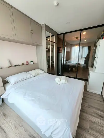 Modern bedroom with sleek design and ample storage in a stylish apartment.