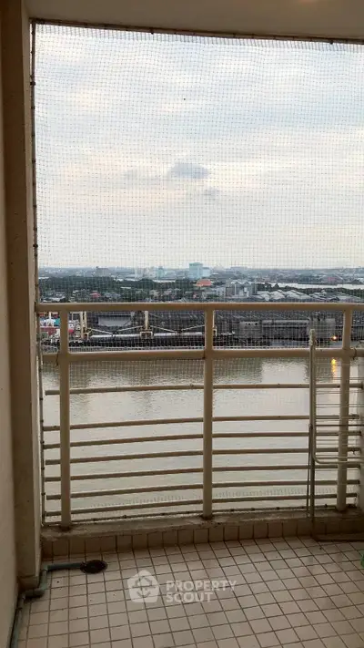 Stunning balcony view overlooking serene river and cityscape, perfect for relaxation.