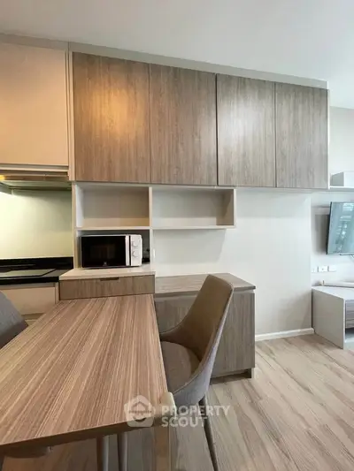 Modern kitchen with sleek wooden cabinets and dining area in a stylish apartment.