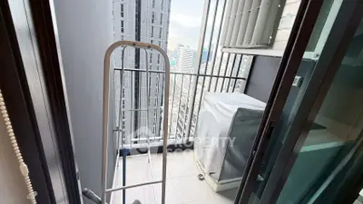 Compact balcony with city view, ideal for urban living, featuring air conditioning unit and laundry rack.