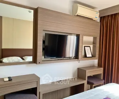 Modern bedroom with built-in TV unit and air conditioning, featuring elegant wood finishes and cozy ambiance.