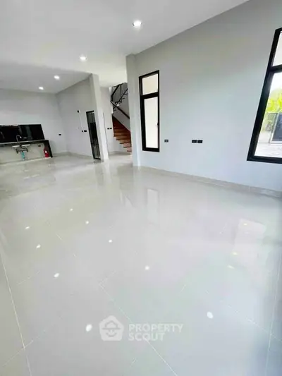 Spacious modern living room with glossy tile flooring and large windows