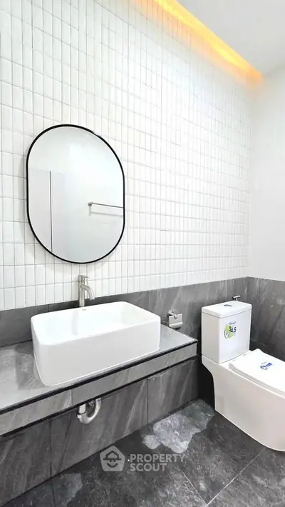 Modern bathroom with sleek design, featuring a stylish mirror and contemporary fixtures.