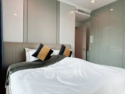 Modern bedroom with stylish decor and plush bedding in a contemporary apartment.