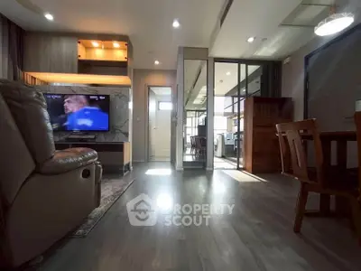 Spacious living room with modern decor and natural light, featuring a cozy seating area and dining space.