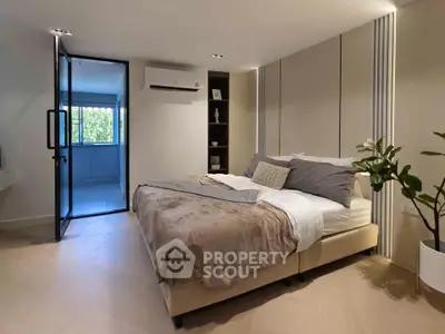 Modern bedroom with cozy decor and natural light, featuring a comfortable bed and stylish furnishings.