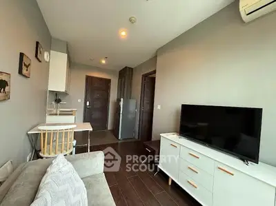 Modern living room with sleek furniture and open kitchen layout in a cozy apartment.