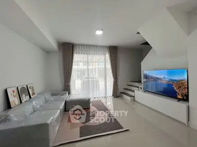 Modern living room with sleek design, large TV, and stylish furniture, perfect for relaxation and entertainment.