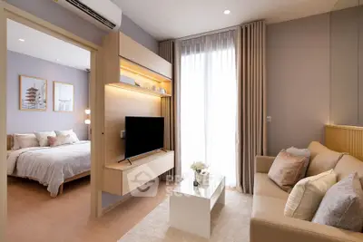 Modern living room with cozy sofa and TV, adjacent to stylish bedroom with natural light.