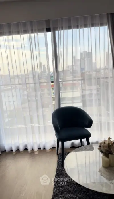 Modern living room with city view, elegant chair, and stylish decor