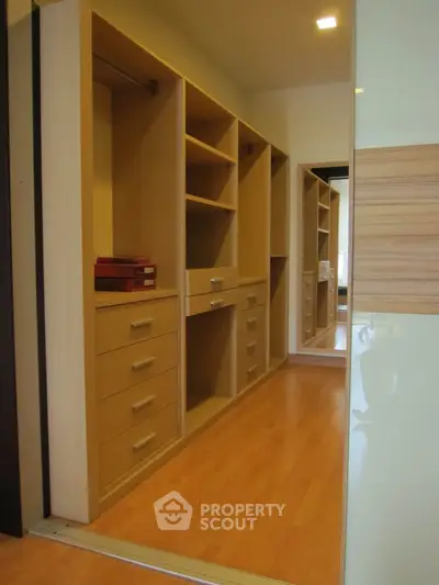 Spacious walk-in closet with wooden shelves and drawers in modern home
