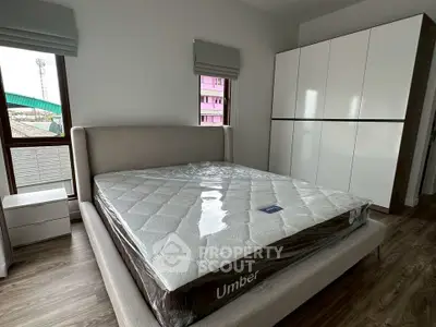 Modern bedroom with stylish bed and sleek wardrobe in a cozy apartment.