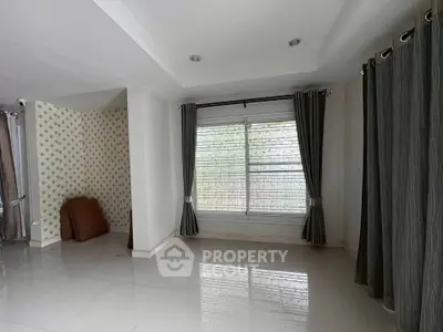 Spacious empty room with large window and elegant curtains, perfect for customization.