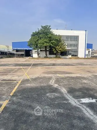 Spacious industrial building with ample parking space and modern facade.