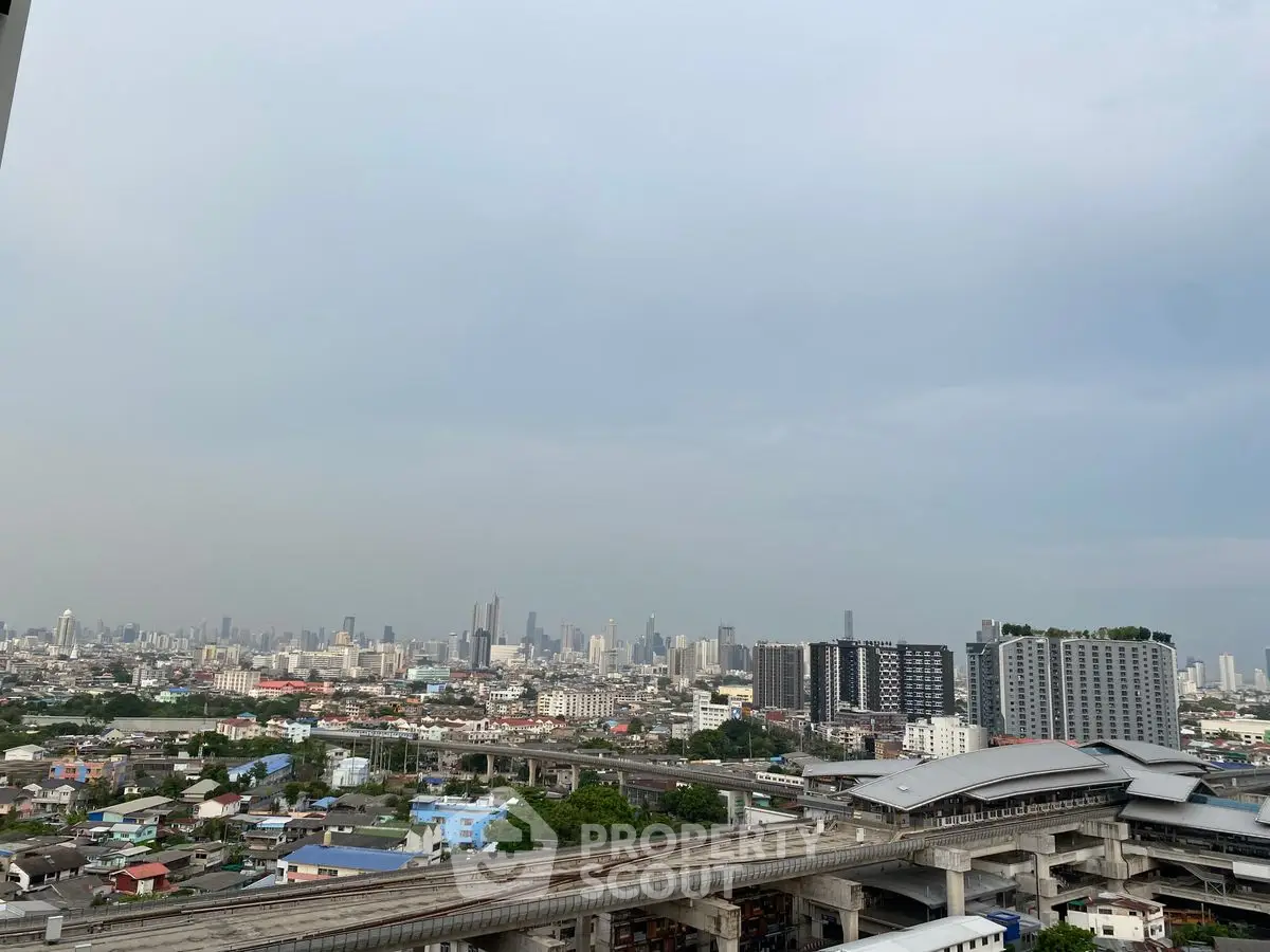 Stunning cityscape view from high-rise building with urban skyline and train tracks.
