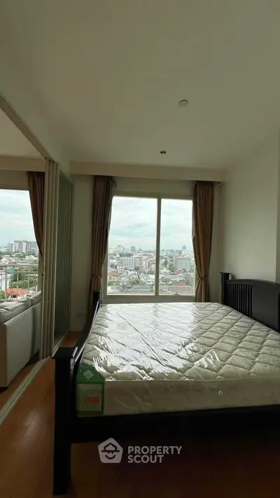 Spacious bedroom with large window offering stunning city views