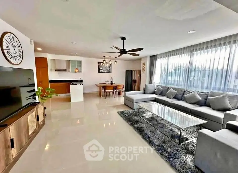 Spacious modern living room with large sectional sofa and open kitchen layout
