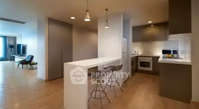 Modern open-plan kitchen and living area with sleek design and stylish lighting.