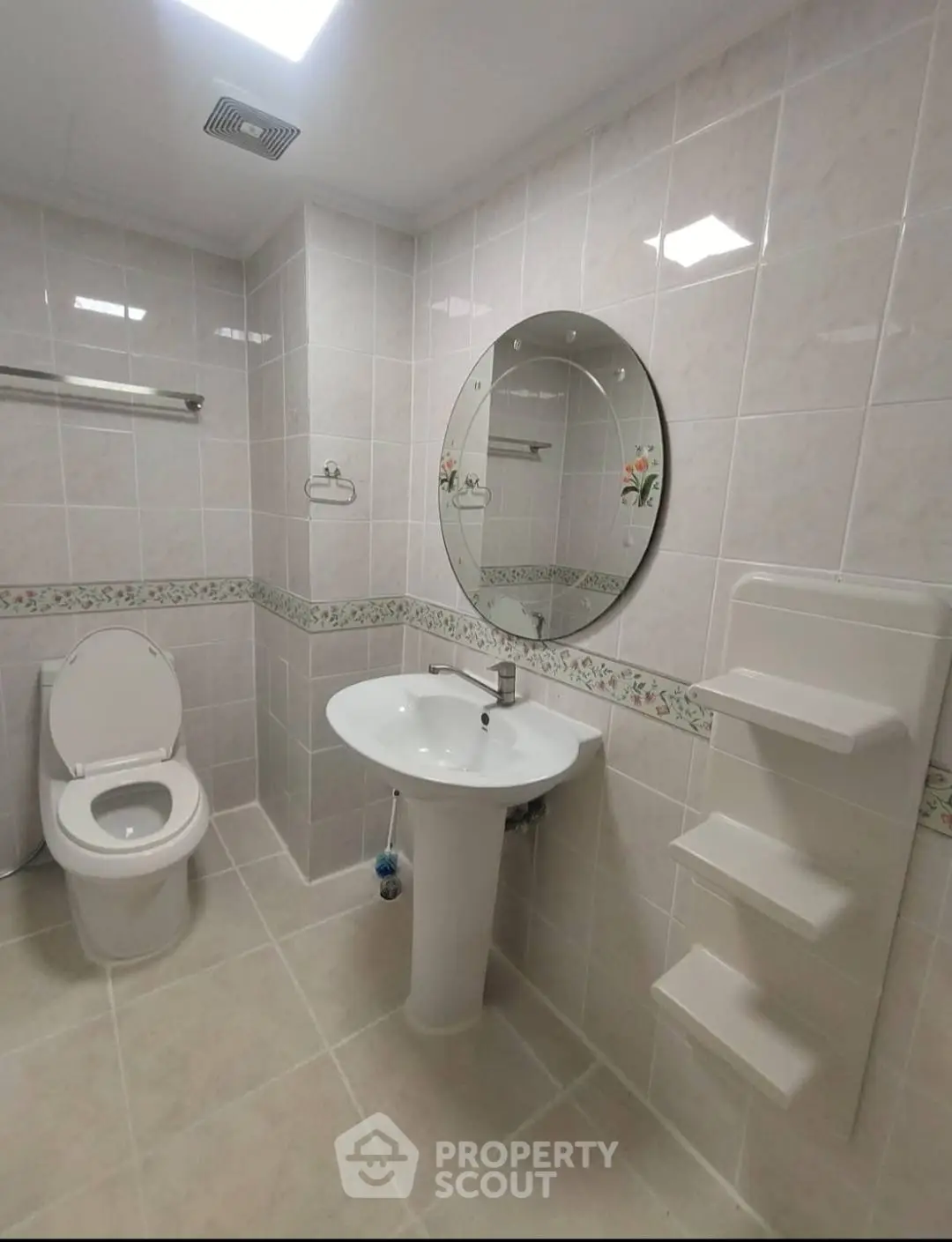 Modern bathroom with elegant tiles and round mirror