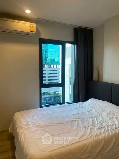 Modern bedroom with city view and air conditioning in urban apartment