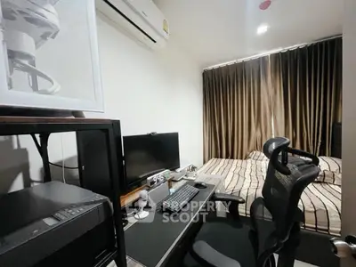 Compact bedroom with integrated study area, featuring modern desk setup and cozy bed.