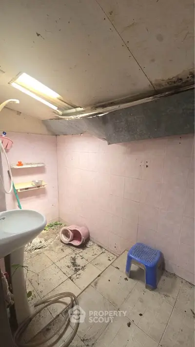 Unfinished bathroom with exposed ceiling and basic fixtures, potential for renovation.