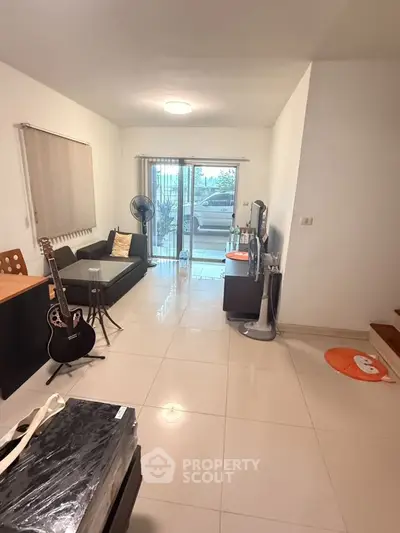 Spacious living room with modern decor and large window view.
