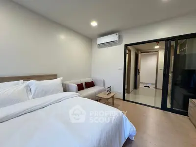 Modern bedroom with cozy sofa and air conditioning in a stylish apartment.