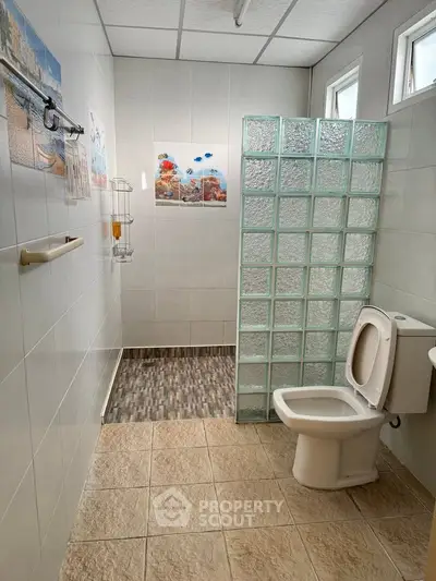 Spacious bathroom with glass block shower and modern fixtures