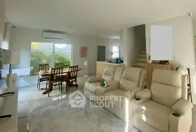 Spacious living room with modern furniture and dining area in a bright open layout.