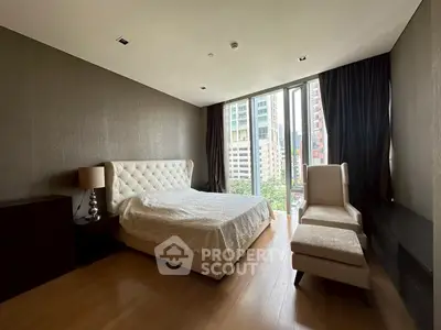 Luxurious bedroom with modern decor and city view, featuring elegant furnishings and large windows.