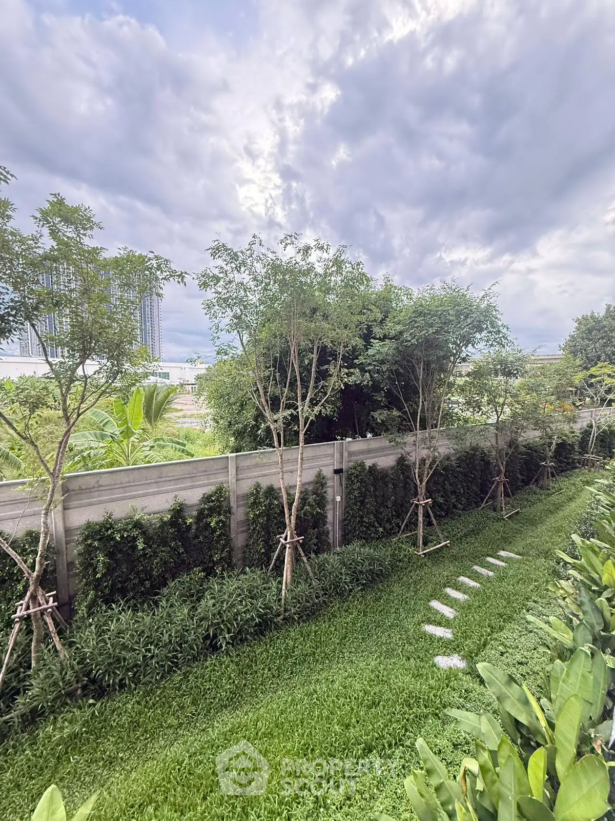 Lush green garden with stepping stones and trees, perfect for serene outdoor living.