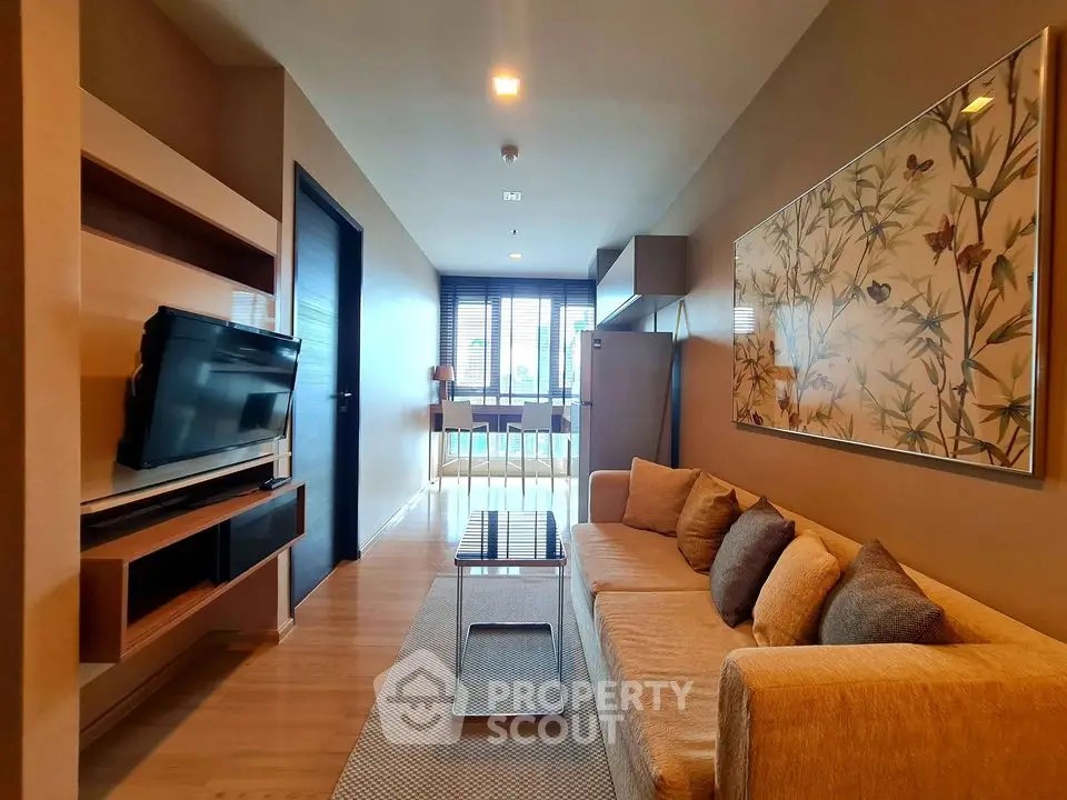 Modern living room with stylish decor and wall art, featuring a cozy sofa and flat-screen TV.