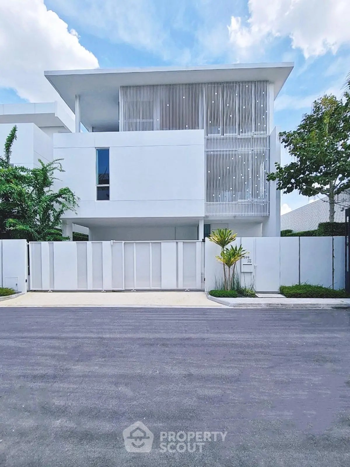 Modern minimalist white building with sleek design and lush greenery