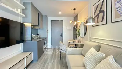 Modern living room with sleek kitchen in open layout, featuring stylish decor and cozy seating.