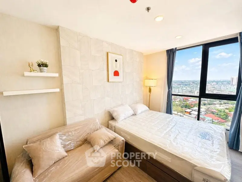 Modern bedroom with city view, featuring cozy bed and stylish decor.