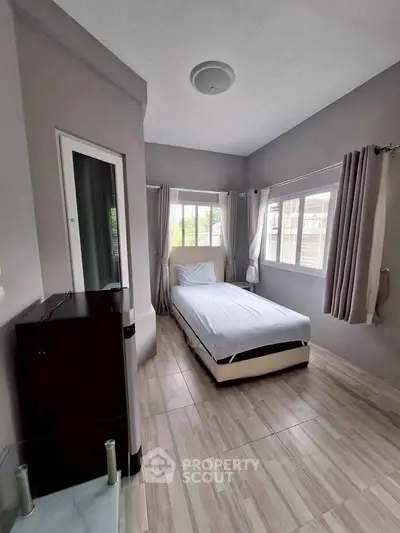 Cozy single bedroom with large windows and modern decor