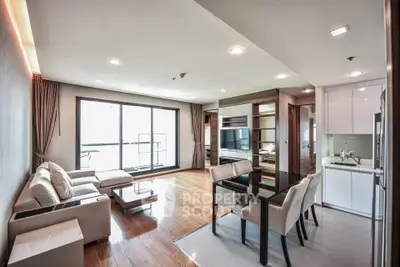 Spacious modern living room with open kitchen and large windows in a stylish apartment.